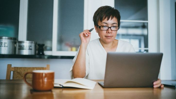 A woman calculates her future expenses in retirement as she puts together a potential budget.