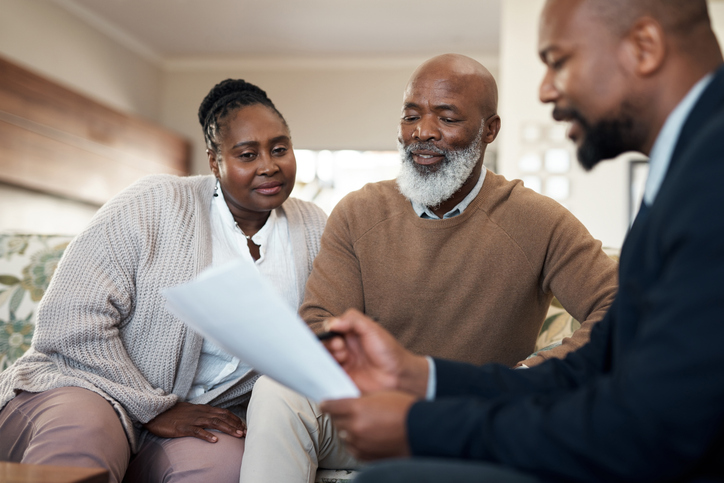 A senior couple meeting with a financial advisor to review their retirement benefits.