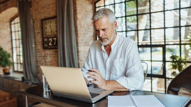 A man looks over his retirement plan options on his laptop.